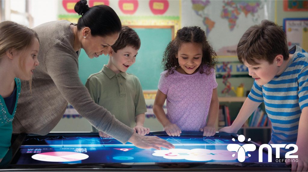 children play interactive games with their teacher at a large touchscreen